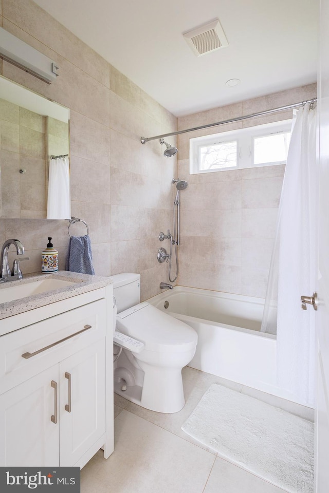 full bath with tile walls, shower / bath combination with curtain, vanity, toilet, and tile patterned flooring
