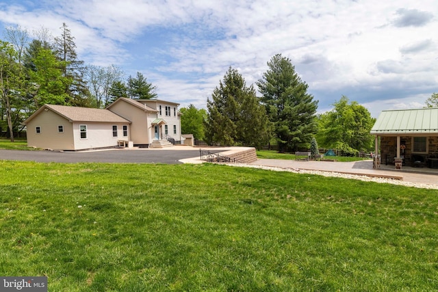view of grassy yard featuring a patio and entry steps