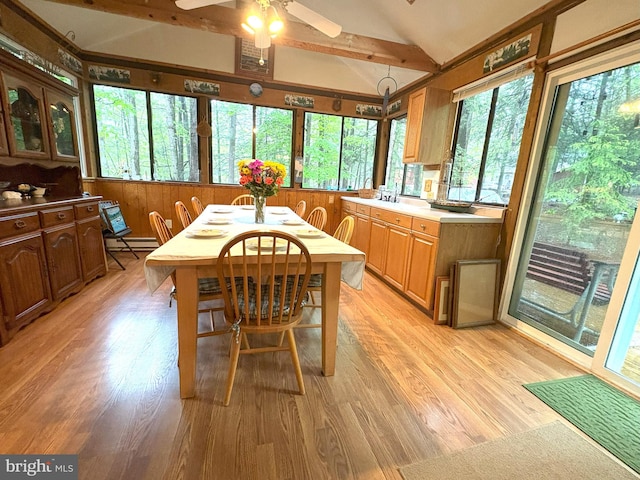 dining room with vaulted ceiling, light wood-style floors, ceiling fan, and a baseboard heating unit