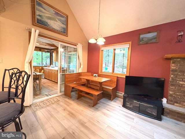 dining space featuring lofted ceiling, wood finished floors, a baseboard radiator, and a chandelier