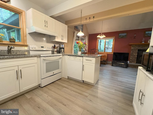 kitchen featuring white appliances, under cabinet range hood, a sink, white cabinets, and vaulted ceiling