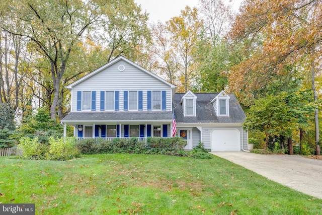 7530 Royce Ct, Annandale, VA 22003 - traditional home with covered porch, driveway, a front lawn, a garage, and view of wooded area
