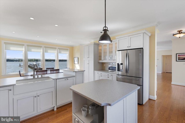 1100 Steamboat Rd, Shady Side, MD 20764 - kitchen featuring appliances with stainless steel finishes, a sink, a kitchen island, crown molding, and glass insert cabinets