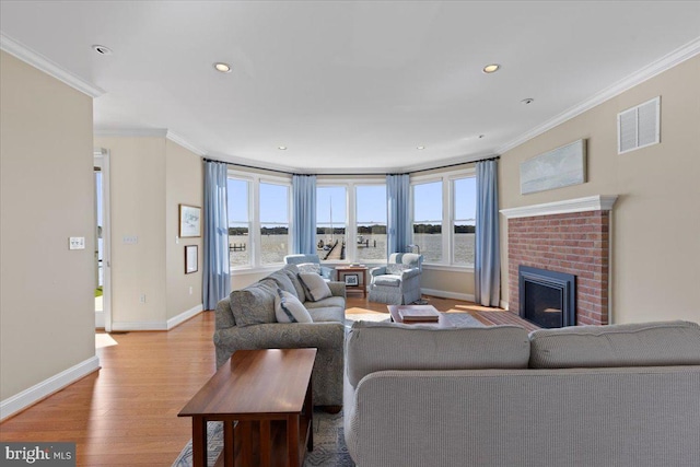 1100 Steamboat Rd, Shady Side, MD 20764 - living room with light wood-style flooring, crown molding, healthy amount of natural light, baseboards, and a brick fireplace