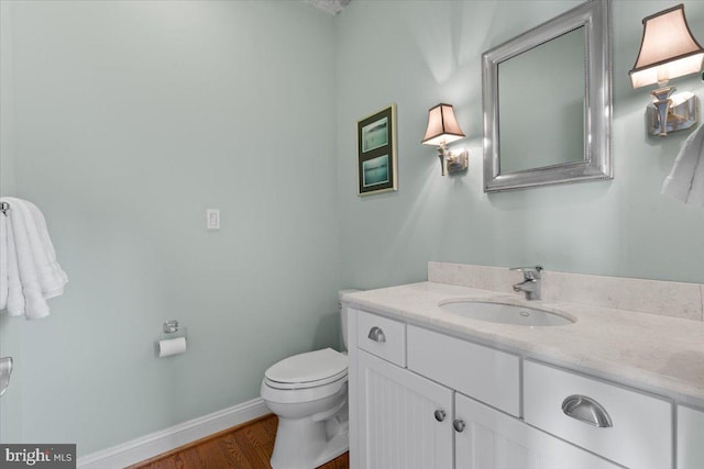 1100 Steamboat Rd, Shady Side, MD 20764 - half bathroom featuring wood finished floors, toilet, baseboards, and vanity