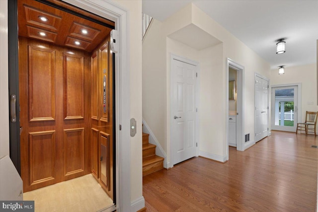 1100 Steamboat Rd, Shady Side, MD 20764 - hall with light wood finished floors, elevator, baseboards, stairway, and recessed lighting