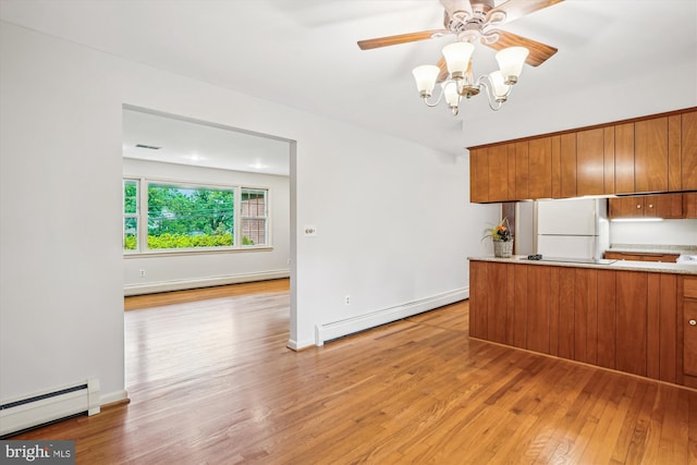 18312 Metz Dr, Germantown, MD 20874 - kitchen featuring freestanding refrigerator, a baseboard heating unit, brown cabinetry, and a baseboard radiator