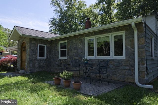 14308 Bristow Rd, Manassas, VA 20112 - view of property exterior featuring stone siding, a chimney, and a patio