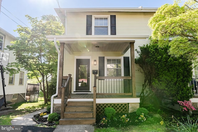 american foursquare style home featuring a porch