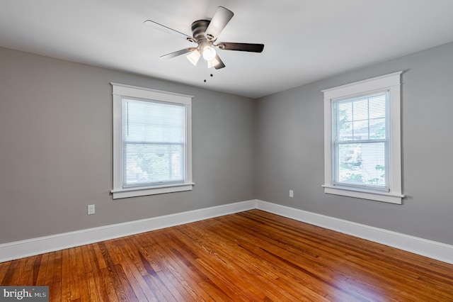 empty room with baseboards, ceiling fan, and wood-type flooring