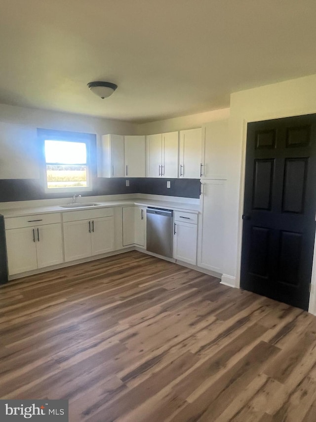 1807 Calvary Church Rd, Warsaw, VA 22572 - kitchen with stainless steel dishwasher, white cabinets, light countertops, wood finished floors, and a sink