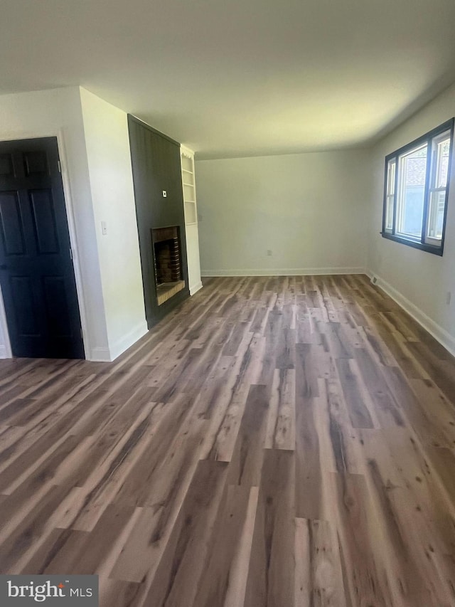 1807 Calvary Church Rd, Warsaw, VA 22572 - unfurnished living room with wood finished floors, baseboards, and a large fireplace