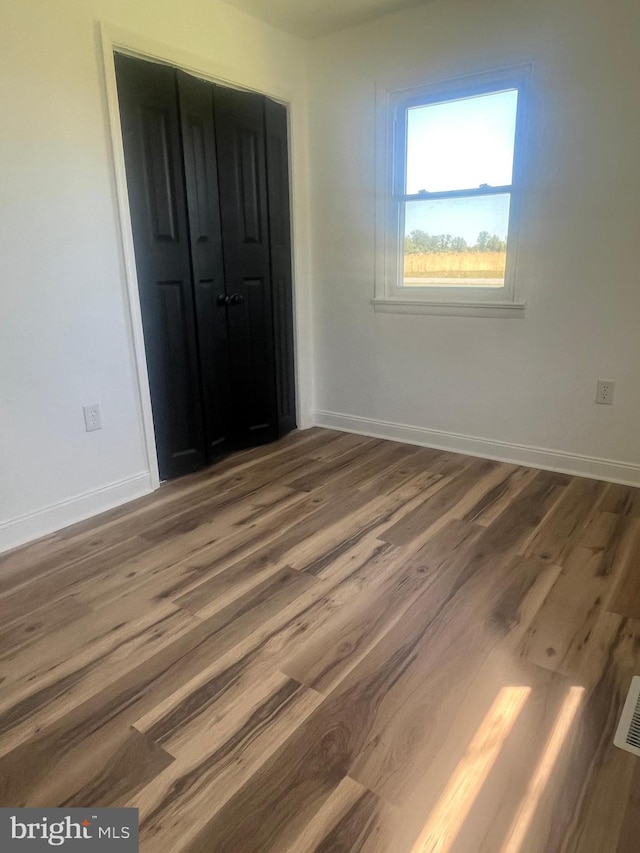 1807 Calvary Church Rd, Warsaw, VA 22572 - unfurnished bedroom featuring wood finished floors, baseboards, and a closet