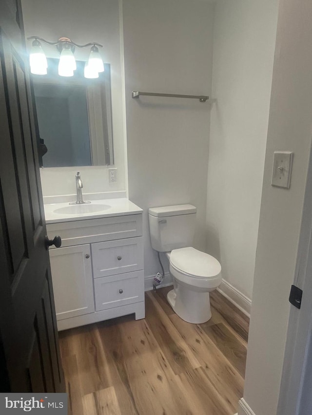 1807 Calvary Church Rd, Warsaw, VA 22572 - bathroom featuring wood finished floors, toilet, vanity, and baseboards