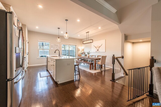 1509 Delphi Ln, Charlottesville, VA 22911 - kitchen with appliances with stainless steel finishes, dark wood-style floors, an island with sink, white cabinets, and a kitchen bar