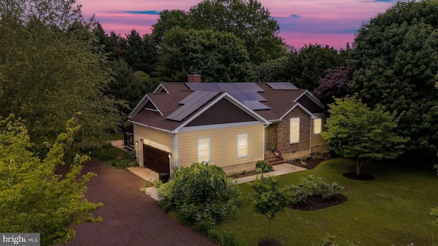 13 Deerfield Ln, Rehoboth Beach, DE 19971 - craftsman-style home featuring driveway, roof mounted solar panels, a chimney, a front lawn, and an attached garage
