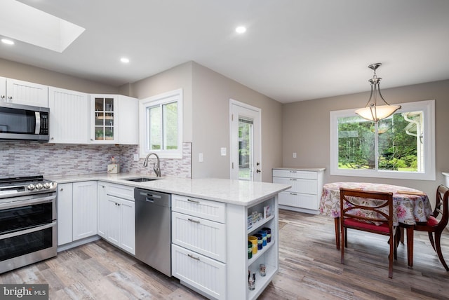 13 Deerfield Ln, Rehoboth Beach, DE 19971 - kitchen with stainless steel appliances, a sink, a peninsula, white cabinetry, and recessed lighting