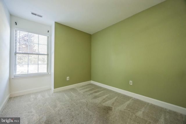 unfurnished room featuring carpet and baseboards