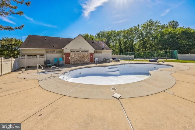 view of swimming pool with a patio area and fence