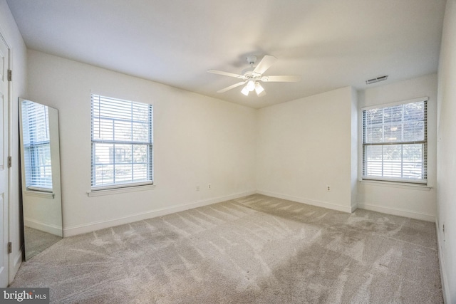 unfurnished room with carpet flooring, ceiling fan, and baseboards