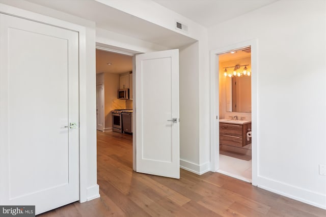 5110 Fort Totten Dr NE Unit P4, Washington, DC 20011 - unfurnished bedroom featuring wood finished floors, a sink, baseboards, a chandelier, and ensuite bathroom