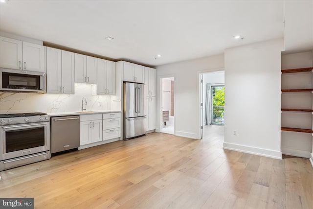 5110 Fort Totten Dr NE Unit P4, Washington, DC 20011 - kitchen with stainless steel appliances, light countertops, light wood-style floors, a sink, and tasteful backsplash