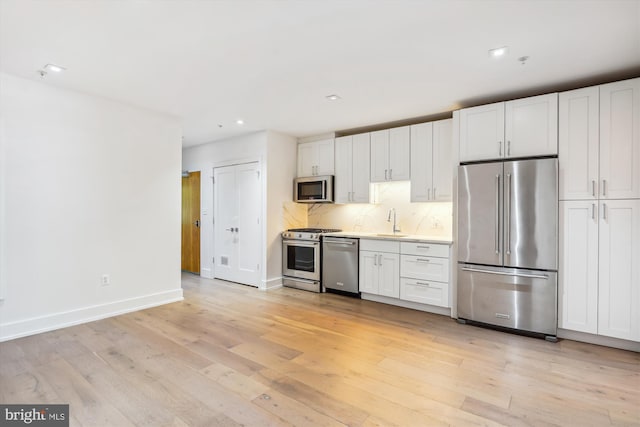 5110 Fort Totten Dr NE Unit P4, Washington, DC 20011 - kitchen with appliances with stainless steel finishes, a sink, light wood-style flooring, white cabinets, and light countertops