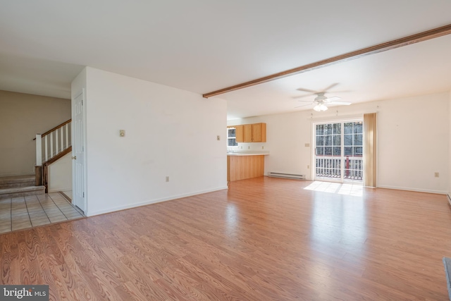 251 Depuy Dr, Pocono Lake, PA 18347 - unfurnished living room featuring a baseboard heating unit, ceiling fan, stairs, light wood finished floors, and baseboards