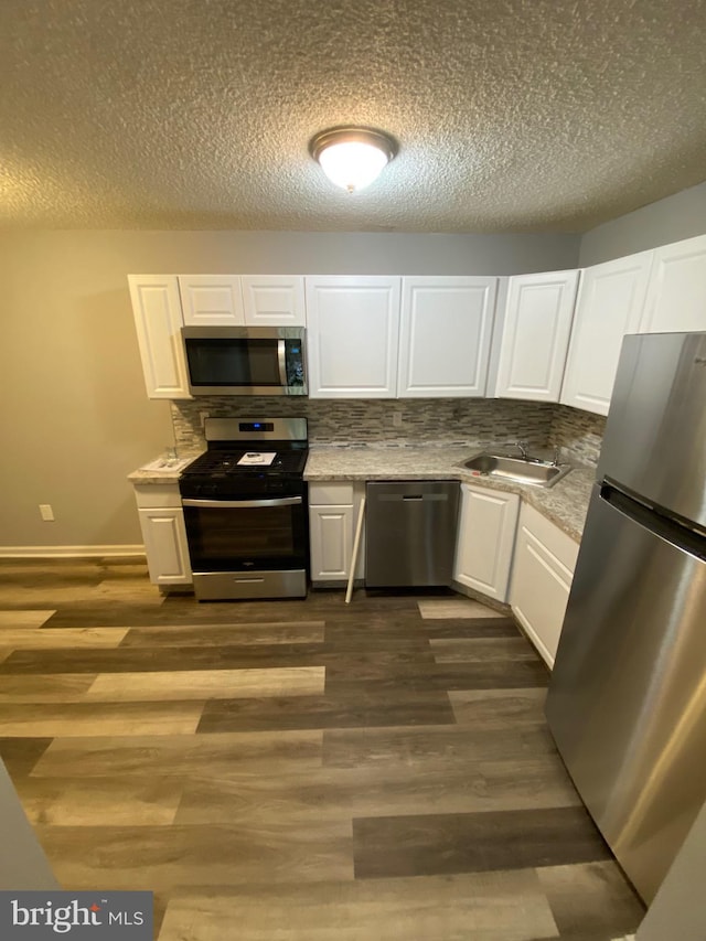 155 Sussex Pl Unit 1522, Absecon, NJ 08205 - kitchen with appliances with stainless steel finishes, a sink, white cabinetry, decorative backsplash, and a textured ceiling