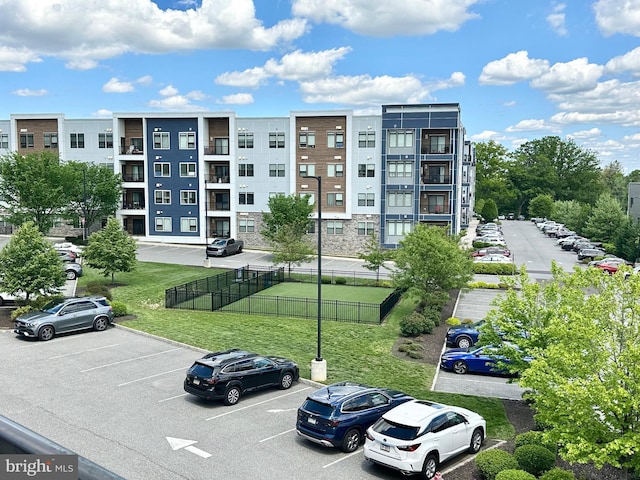 view of property featuring uncovered parking and fence