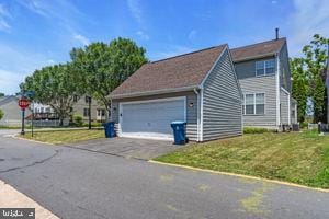 42783 Freedom St, Chantilly, VA 20152 - view of side of home with a lawn, an attached garage, and asphalt driveway