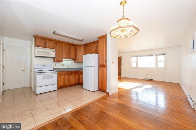 1426 W 11th St, Frederick, MD 21702 - kitchen with white appliances, light wood finished floors, baseboards, and brown cabinetry