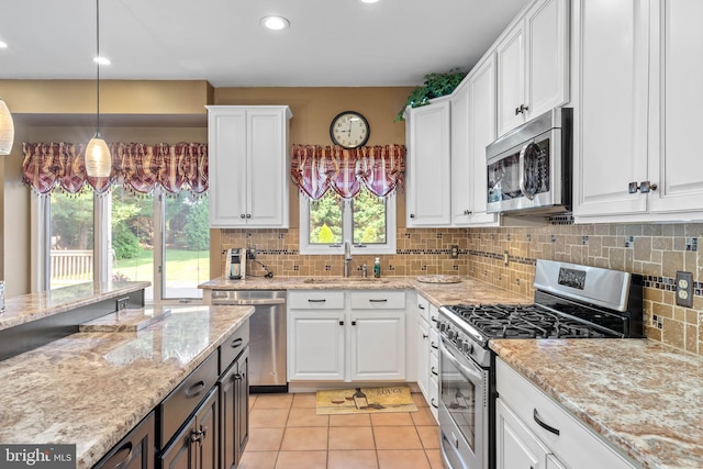 123 Nantucket Dr, Middletown, DE 19709 - kitchen featuring stainless steel appliances, a sink, white cabinets, light tile patterned flooring, and backsplash