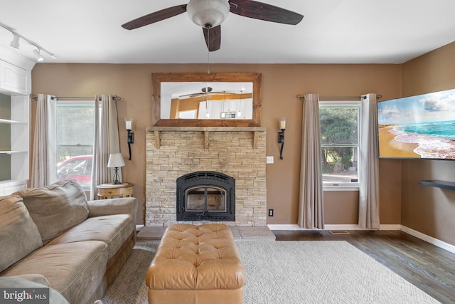 123 Nantucket Dr, Middletown, DE 19709 - living area with track lighting, ceiling fan, a stone fireplace, wood finished floors, and baseboards