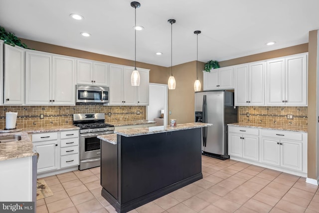 123 Nantucket Dr, Middletown, DE 19709 - kitchen featuring appliances with stainless steel finishes, decorative backsplash, white cabinetry, a kitchen island, and recessed lighting