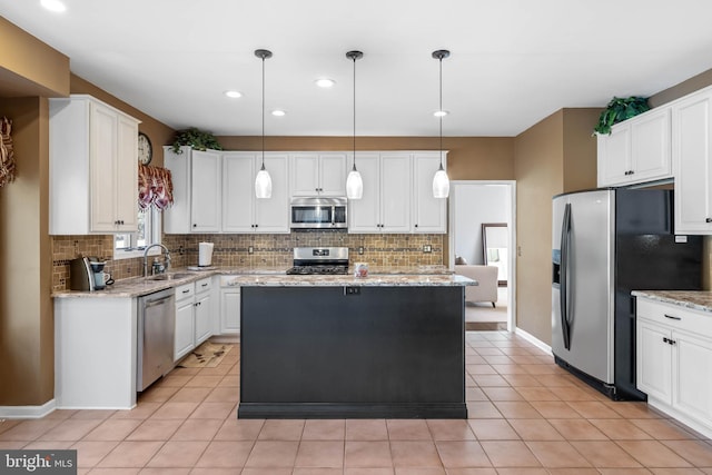 123 Nantucket Dr, Middletown, DE 19709 - kitchen featuring appliances with stainless steel finishes, decorative backsplash, white cabinets, a kitchen island, and recessed lighting