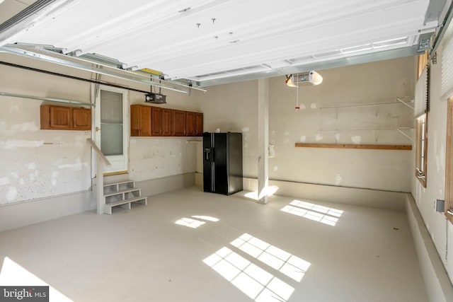 123 Nantucket Dr, Middletown, DE 19709 - garage featuring black fridge with ice dispenser and a garage door opener