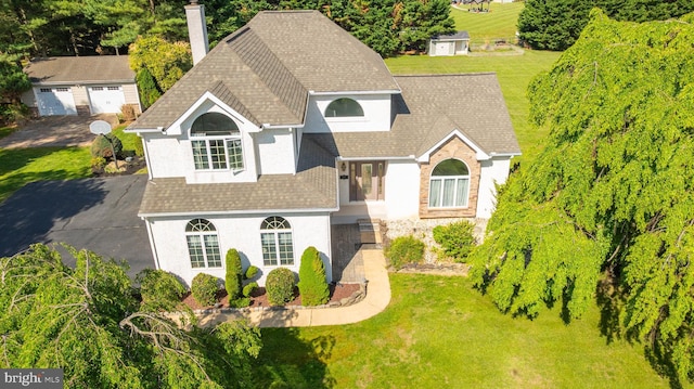 123 Nantucket Dr, Middletown, DE 19709 - view of front of home featuring a shingled roof, an outdoor structure, a chimney, stucco siding, and a front lawn