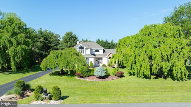 123 Nantucket Dr, Middletown, DE 19709 - view of front facade featuring a front lawn, a chimney, and asphalt driveway