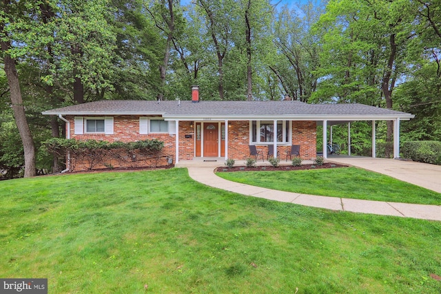 single story home featuring brick siding, driveway, a front yard, a carport, and a chimney