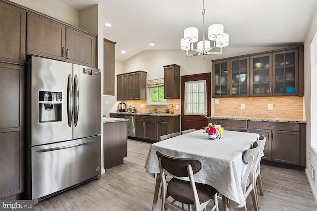 kitchen featuring stainless steel fridge with ice dispenser, a chandelier, light wood-style flooring, dark brown cabinets, and vaulted ceiling