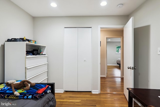 bedroom with recessed lighting, wood finished floors, and baseboards