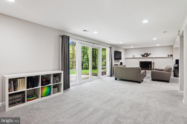 carpeted living room featuring recessed lighting and a brick fireplace