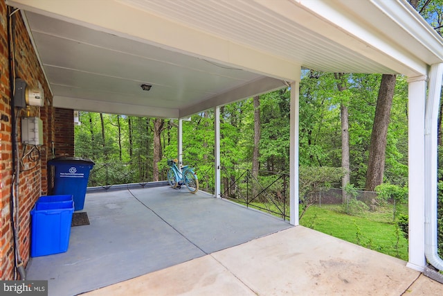 view of patio / terrace with a carport and a wooded view