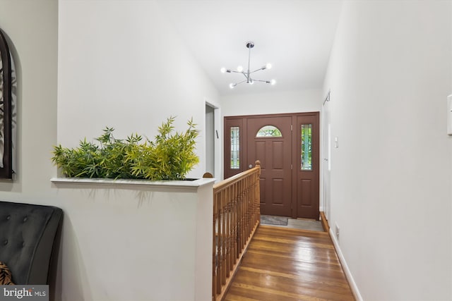 foyer with a chandelier, wood finished floors, and baseboards