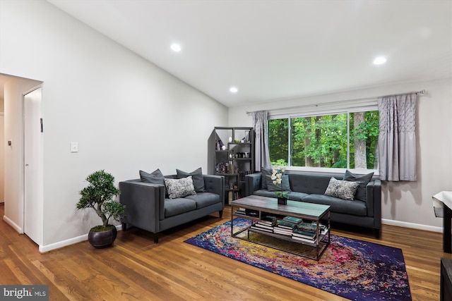 living area featuring wood finished floors, vaulted ceiling, baseboards, and recessed lighting