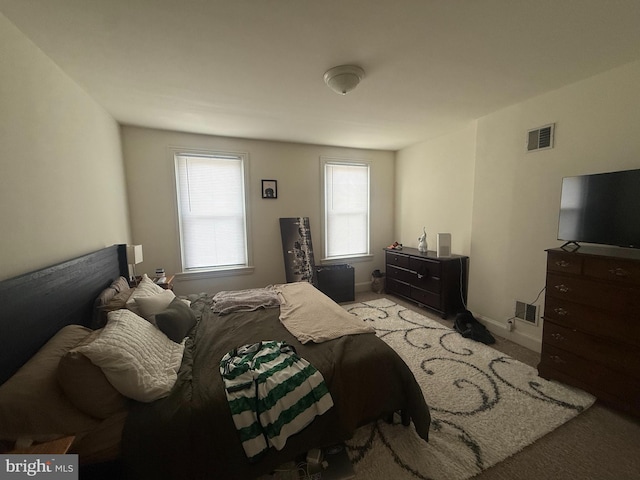 bedroom featuring light colored carpet and baseboards