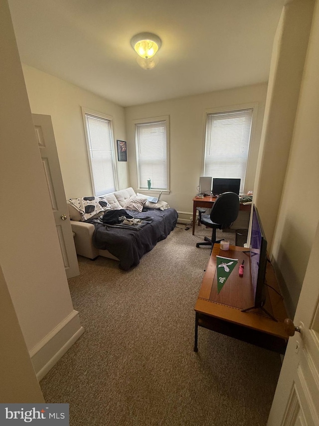 carpeted bedroom featuring baseboards and a desk