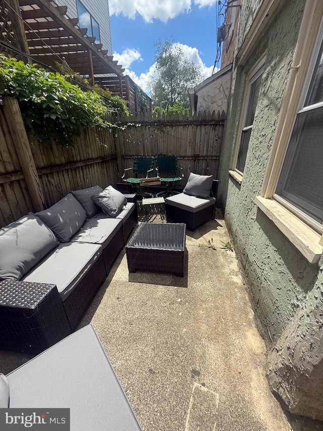 view of patio / terrace with an outdoor living space, fence, and a pergola