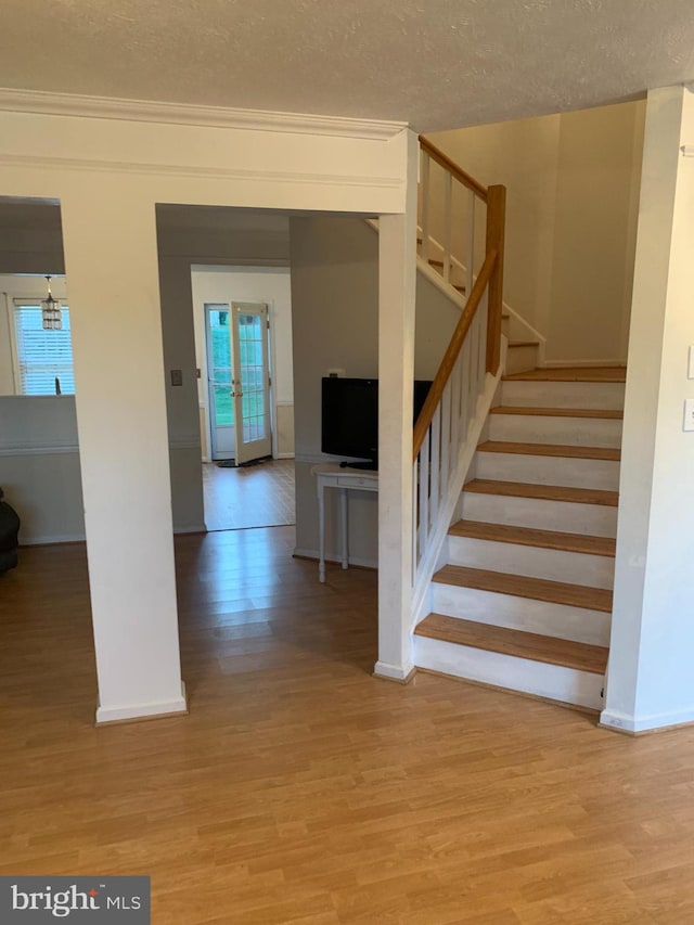 1170 Hisey Ave, Woodstock, VA 22664 - stairway featuring wood finished floors, plenty of natural light, a textured ceiling, and baseboards